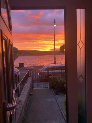 a view of a sunset from a window of a house at Harbour View in Rothesay