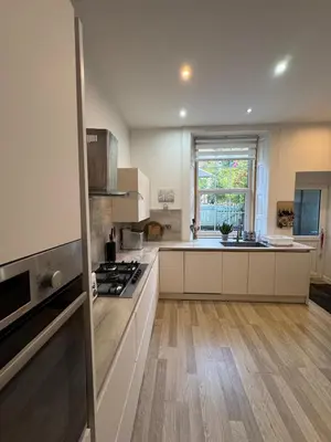 a kitchen with white cabinets and a stove top oven at Harbour View in Rothesay