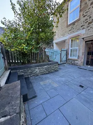 a house with a fence and a stone patio at Harbour View in Rothesay