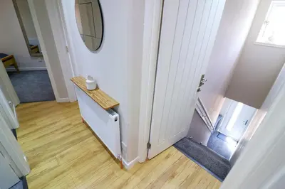 a hallway with a staircase with a table and a mirror at Signature - Wellhead View in Lanark