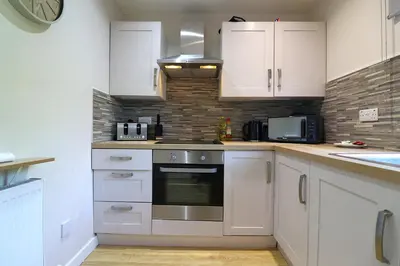 a kitchen with white cabinets and a stove top oven at Signature - Wellhead View in Lanark