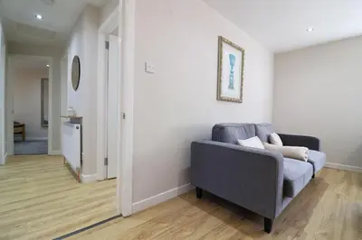 a living room with a gray couch and a hallway at Signature - Wellhead View in Lanark