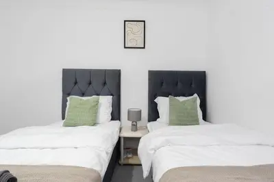 two beds sitting next to each other in a bedroom at Free Parking - Sleeps 6 - 2 Bedrooms - Newly Renovated in Greenock