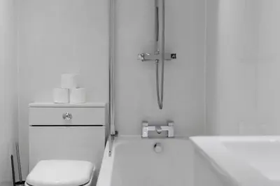 a white bathroom with a toilet and a sink at Free Parking - Sleeps 6 - 2 Bedrooms - Newly Renovated in Greenock