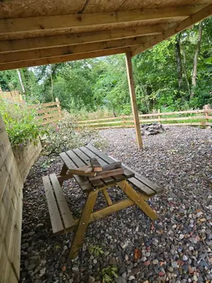 a picnic table and a bench under a pavilion at Ben Lomond Apartment in Tarbet