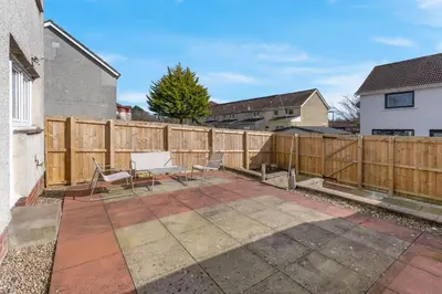a patio with two chairs and a fence at Free Parking - Central - Sleeps 8 - 3 Bedrooms in Livingston