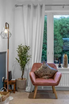 a living room with a chair and a window at Free Parking - Central - Sleeps 6 - 2 Bedrooms in East Calder