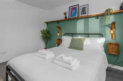 a bedroom with a white bed with towels on it at Free Parking - Central - Sleeps 6 - 2 Bedrooms in East Calder