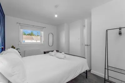 a white bedroom with a bed and a window at Free Parking - Central - Sleeps 6 - 2 Bedrooms in Livingston