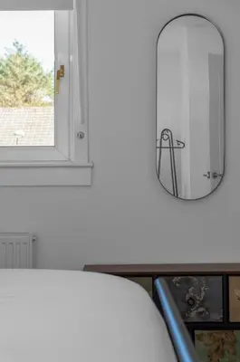 a mirror on a wall next to a table at Free Parking - Central - Sleeps 6 - 2 Bedrooms in Livingston