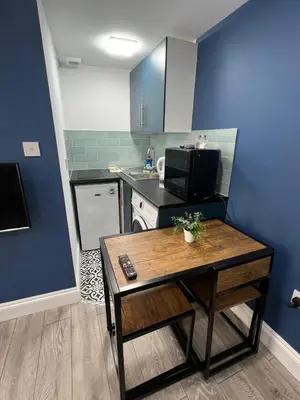 a small kitchen with a table and a microwave at Love Shack - Cozy 1BR Walthamstow in Moffat