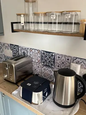 a kitchen counter with a toaster and a toaster and a slow cooker at 2 bedroom cottage in Ayr