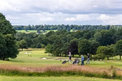 a group of people playing golf on a golf course at Edinburgh whole house let for DP World Tour, overlooking Bruntsfield Links 18th fairway, 30 min drive from The Renaissance Club in Edinburgh