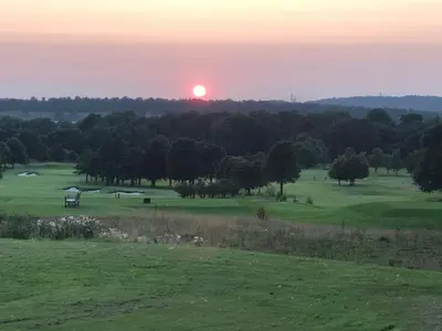 a sunset over a golf course with the sun in the sky at Edinburgh whole house let for DP World Tour, overlooking Bruntsfield Links 18th fairway, 30 min drive from The Renaissance Club in Edinburgh