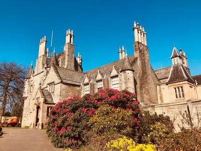 an old stone building with flowers in front of it at Edinburgh whole house let for DP World Tour, overlooking Bruntsfield Links 18th fairway, 30 min drive from The Renaissance Club in Edinburgh