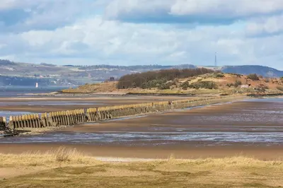 a fence on a beach near the water at Edinburgh whole house let for DP World Tour, overlooking Bruntsfield Links 18th fairway, 30 min drive from The Renaissance Club in Edinburgh