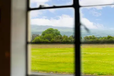 a view of a field of grass from a window at Cultybraggan Hut 38 - Accessible in Comrie