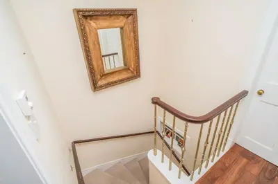 a mirror on the wall next to a stairway at New Town Cottage in Edinburgh