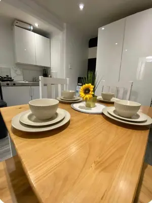 a wooden table with bowls and plates on it in a kitchen at Apartment in the heart of London in Moffat