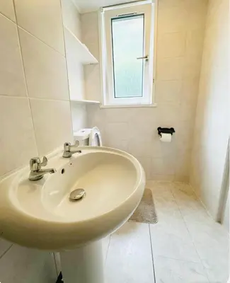 a bathroom with a sink and a window at Private Room in Glasgow City in Hillfoot