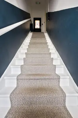 a staircase in a building with a blue wall at Modern Comfort in Historic Callander in Stirling