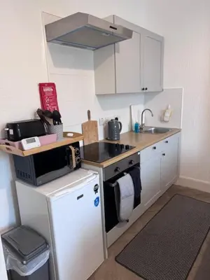 a small kitchen with a stove and a microwave at Balloch But & Ben in Balloch