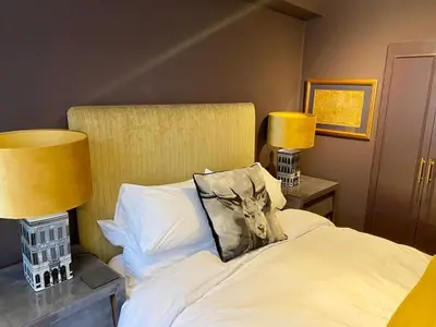 a bedroom with a white bed with two lamps at Elegant Chelsea Apartment in Moffat