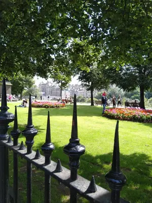 a black fence in a park with flowers at Comfortable room with en suite in Edinburgh