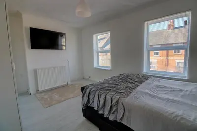 a bedroom with a bed and a flat screen tv at Home in Reading Uni Area in Moffat