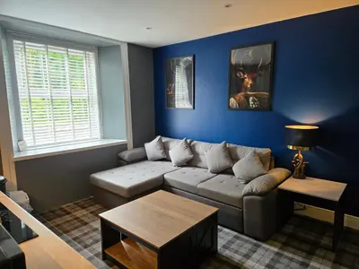 a living room with a couch and a table at Stlll Brae Apartment in Tarbet