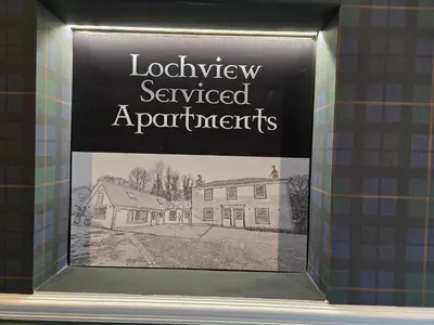 a picture of a house in a display window at Stlll Brae Apartment in Tarbet