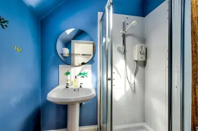 a blue bathroom with a sink and a shower at Argyll Farmhouse-Idyllic Setting-Sleeps10 in Dunoon