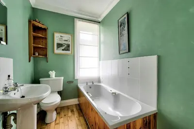 a bathroom with a tub and a toilet and a sink at Argyll Farmhouse-Idyllic Setting-Sleeps10 in Dunoon