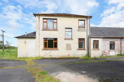 an old white house with orange doors and windows at Shawsmill, outside Hurlford in Hurlford