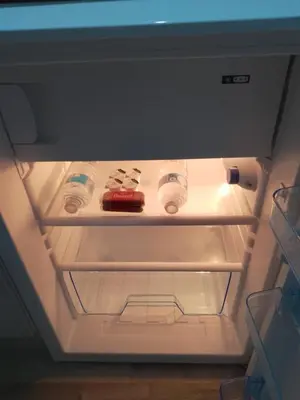 an open refrigerator with bottles of water in it at Studio Twenty One in Whitburn