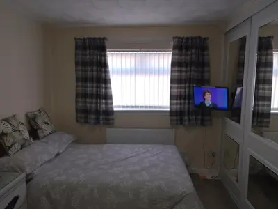 a bedroom with a bed and a flat screen tv at Studio Twenty One in Whitburn