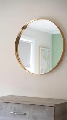 a mirror on a wall above a wooden dresser at Graham House in Livingston