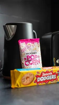 a cup of coffee and a box of popcorn and a bag of food at 4 BDR House By Caledonia Luxe Stays Short Lets & Serviced Accommodation Livingston in Livingston