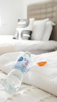 a bottle of water sitting on top of a bed at 4 BDR House By Caledonia Luxe Stays Short Lets & Serviced Accommodation Livingston in Livingston