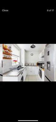a kitchen with white cabinets and a white refrigerator at Private room - Central NN1 stay in Moffat