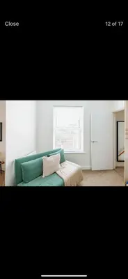 a living room with a green couch and a window at Private room - Central NN1 stay in Moffat