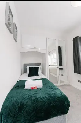 a bedroom with a large bed with a green blanket at Asentral Homes in Moffat
