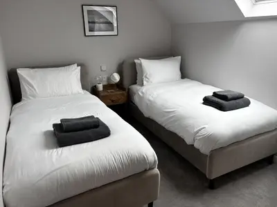 two beds in a room with two towels on them at No4 Invereoch in Arrochar