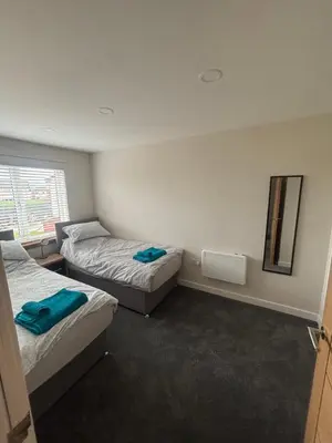 a room with two beds and a mirror at 25 Colliers Road,Stirling
