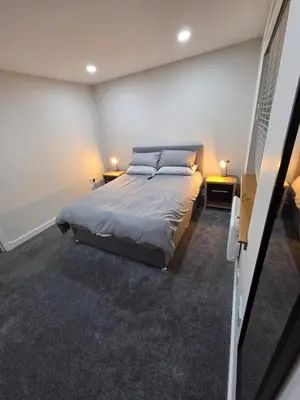 a bedroom with a large bed and two tables at 25 Colliers Road,Stirling