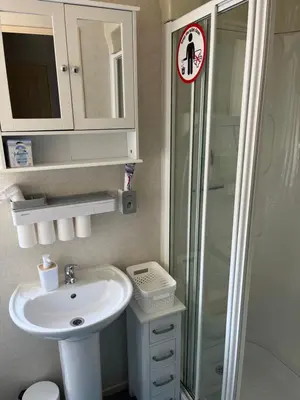 a bathroom with a white sink and a shower at Static Caravan in Moffat