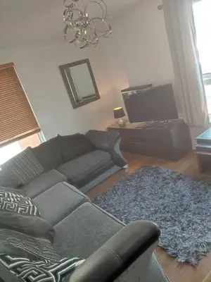 a living room with a couch and a tv at Rosebank Apartment Edinburgh City in Edinburgh