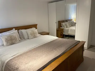 a bedroom with a large bed and a mirror at Detached Annexe in Moffat
