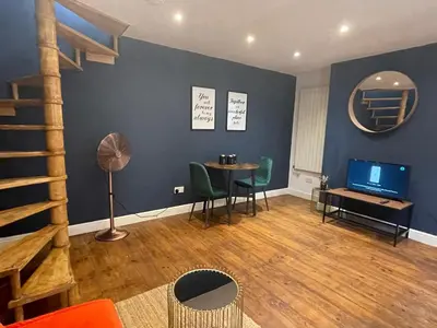 a living room with a staircase and a table and chairs at First Avenue Apartments in Moffat