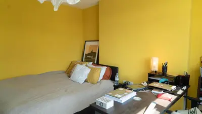 a yellow room with a bed and a desk with a desk at 3 bedroom cosy apartment 20 mins to Centre in Moffat